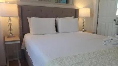 a bedroom with a white bed with two lamps at Sunshine Room by harbor downtown beach I-95&Train in Stamford