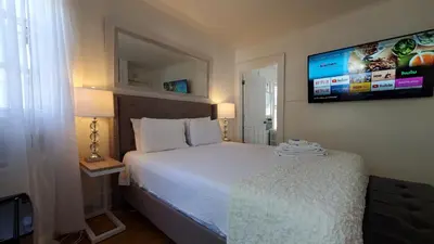 a bedroom with a bed and a tv on the wall at Sunshine Room by harbor downtown beach I-95&Train in Stamford