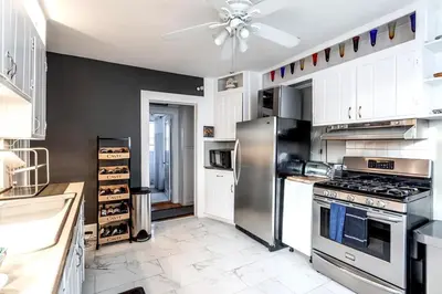 a kitchen with a stainless steel refrigerator and white cabinets at Bella room near downtown Train I-95 & beaches in Stamford