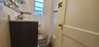 a bathroom with a sink and a toilet with a window at Bella room near downtown Train I-95 & beaches in Stamford
