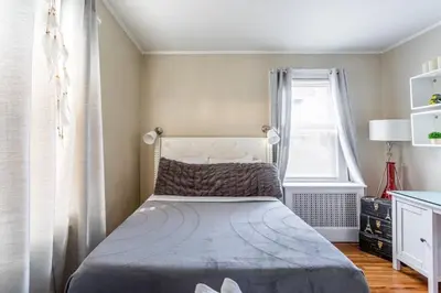 a small bedroom with a bed and a window at Bella room near downtown Train I-95 & beaches in Stamford