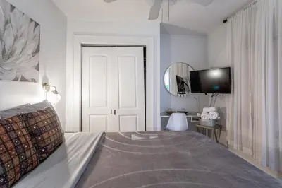 a bedroom with a bed and a tv on the wall at The Gold Room near downtown trains fast wifi in Stamford