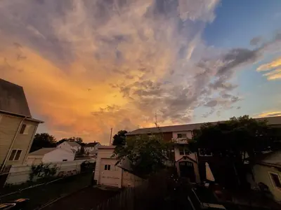 a cloudy sky at sunset with houses and buildings at The Gold Room near downtown trains fast wifi in Stamford