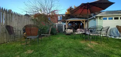 a group of chairs and an umbrella in a yard at The Gold Room near downtown trains fast wifi in Stamford