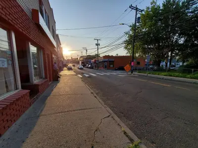 an empty street next to a red building with the sun setting at The Gold Room near downtown trains fast wifi in Stamford