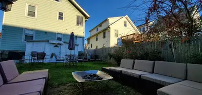 a backyard with a couch and a table and a house at Stamford Bohemian by HarborPoint Downtown &Train in Stamford