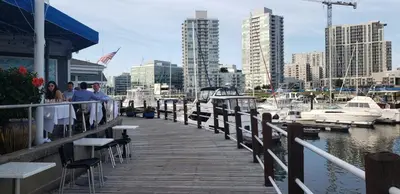 a dock with people standing on it next to a marina at Stamford Bohemian by HarborPoint Downtown &Train in Stamford