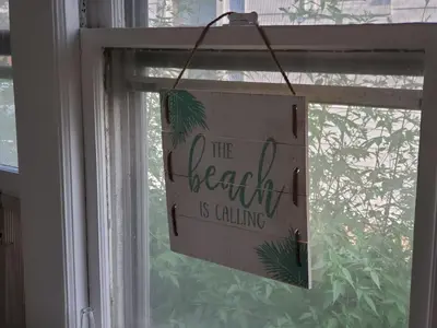 a sign that says the beach is calling hanging in a window at Stamford Bohemian by HarborPoint Downtown &Train in Stamford