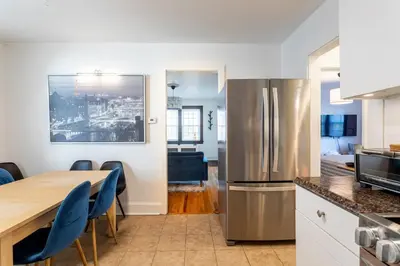 a kitchen with a wooden table and a refrigerator at The Blue Sapphire 2BR 2 King beds & ample backyard in Bridgeport