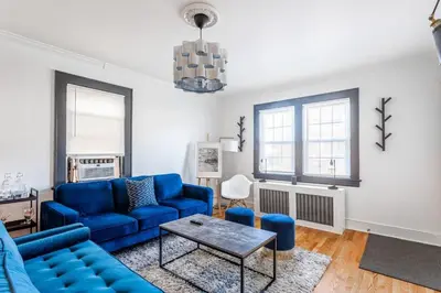 a living room with a blue couch and a table at The Blue Sapphire 2BR 2 King beds & ample backyard in Bridgeport