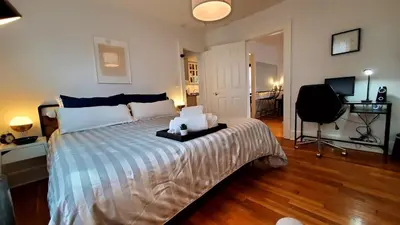 a bedroom with a bed with a desk and a television at The Blue Sapphire 2BR 2 King beds & ample backyard in Bridgeport