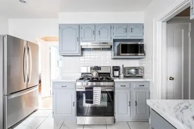 a kitchen with white cabinets and a stove top oven at The B&W Haven 3BR private office by LI Ferry in Bridgeport
