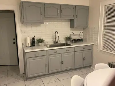 a kitchen with white cabinets and a sink at The B&W Haven 3BR private office by LI Ferry in Bridgeport
