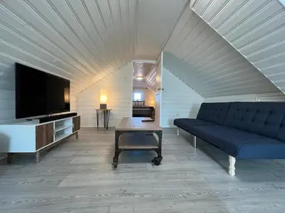 a living room with a blue couch and a tv at The B&W Haven 3BR private office by LI Ferry in Bridgeport