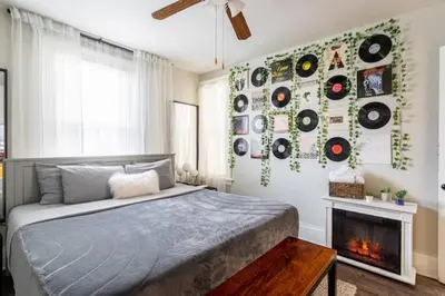 a bedroom with a bed with records on the wall at Revamped 3BR Apt with Easy Check-In Family-Friendly in Bridgeport