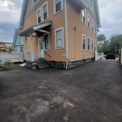 a large house with a driveway in front of it at Revamped 3BR Apt with Easy Check-In Family-Friendly in Bridgeport