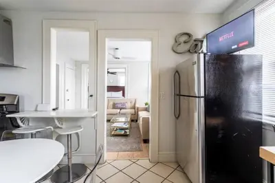 a kitchen with a refrigerator and a living room at Revamped 3BR Apt with Easy Check-In Family-Friendly in Bridgeport
