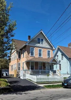 a large house with a white fence in front of it at Revamped 3BR Apt with Easy Check-In Family-Friendly in Bridgeport