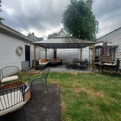 a patio with tables and chairs and an umbrella at Revamped 3BR Apt with Easy Check-In Family-Friendly in Bridgeport