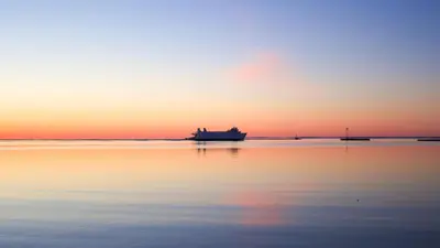 a boat sitting in the water at sunset at Revamped 3BR Apt with Easy Check-In Family-Friendly in Bridgeport