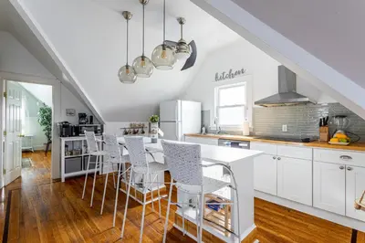 a kitchen with white cabinets and a table and chairs at Charming 2BR Getaway with Modern Comforts in Bridgeport