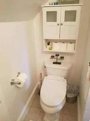 a bathroom with a toilet and a white cabinet at Charming 2BR Getaway with Modern Comforts in Bridgeport