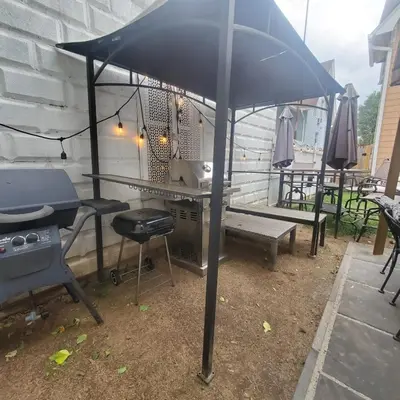 an umbrella on a patio with a grill and a table at Charming 2BR Getaway with Modern Comforts in Bridgeport