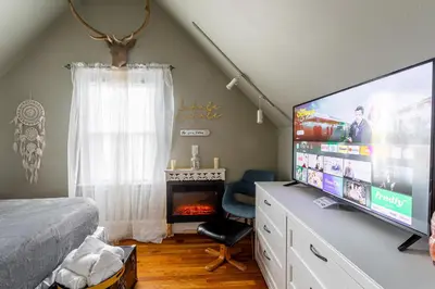 a bedroom with a flat screen tv and a fireplace at Charming 2BR Getaway with Modern Comforts in Bridgeport