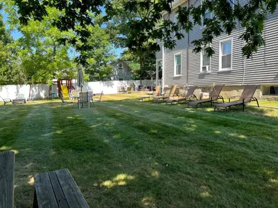 a group of benches sitting in the grass near a house at Sunny & Spacious 2BD 1BA WFH Apt-Huge Yard & Patio in Fairfield