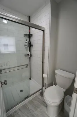 a bathroom with a toilet and a glass shower at Perfect Vacation Home with Game Room Theater Hot Tub in Tobyhanna