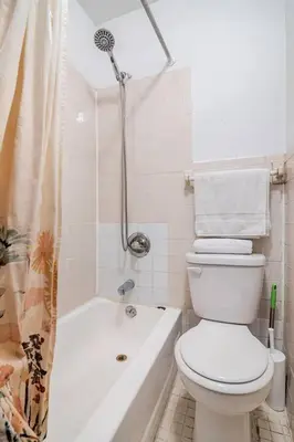 a white bathroom with a toilet and a shower at 89-2R 1BR Upper East Side in New York