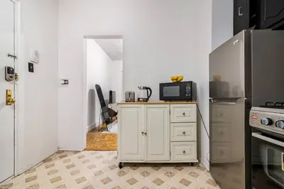 a kitchen with a counter with a microwave and a refrigerator at 89-2R 1BR Upper East Side in New York