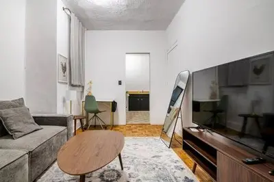 a living room with a couch and a flat screen tv at 89-2R 1BR Upper East Side in New York