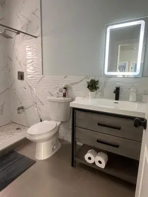 a white bathroom with a toilet and a sink at MetLife Stadium Apartments Near NYC in Jersey City