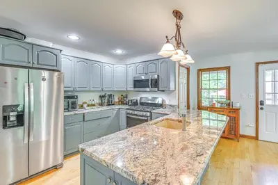 a kitchen with stainless steel appliances and a marble counter top at Charming Ballston Spa Home with Sauna and Private Pool in Ballston Spa