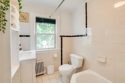 a white bathroom with a toilet and a sink at Hackensack Escape with Yard - 17 Mi to Times Square! in Hackensack
