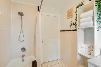 a white bathroom with a shower and a tub at Hackensack Escape with Yard - 17 Mi to Times Square! in Hackensack