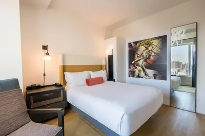 a hotel room with a large white bed and a window at Hotel Indigo Lower East Side New York by IHG in New York