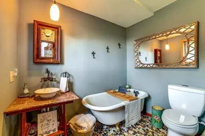 a bathroom with a tub and a toilet and a mirror at Secluded Oxford Cabin on 75 Acres Sunset Views! in Oxford