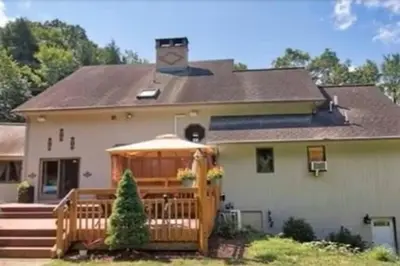 a house with a porch with an umbrella at NatureGlow Residence Stylish Contemporary Home in Harwinton