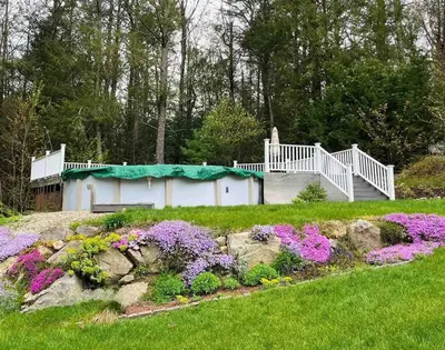 a garden with flowers in front of a house at NatureGlow Residence Stylish Contemporary Home in Harwinton