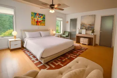 a bedroom with a large white bed and a couch at NatureGlow Residence Stylish Contemporary Home in Harwinton
