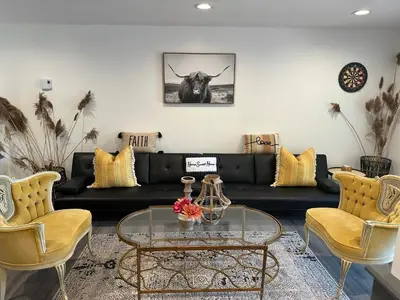 a living room with a black couch and a table at Majestic Lake Front Chalet in Tobyhanna