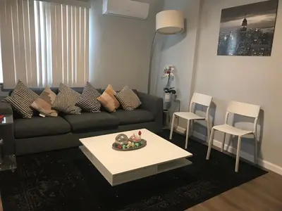 a living room with a couch and a table and chairs at 30 mins to TIMES SQ!!!! in Corona