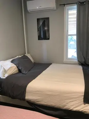 two beds in a bedroom with a window at 30 mins to TIMES SQ!!!! in Corona