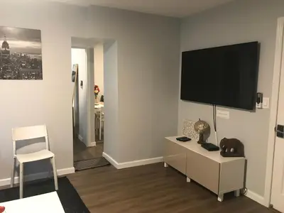 a living room with a flat screen tv on a wall at 30 mins to TIMES SQ!!!! in Corona