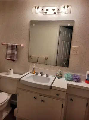a bathroom with a sink and a toilet and a mirror at On the Water Spacious Comfortable Historic House in West Haven