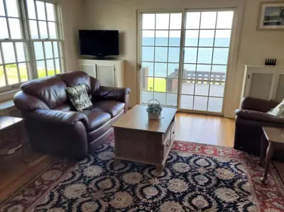 a living room with a leather couch and a coffee table at On the Water Spacious Comfortable Historic House in West Haven