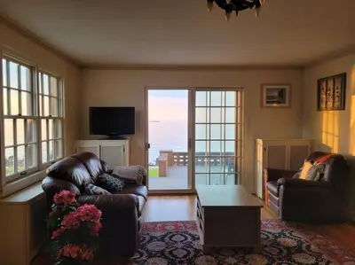 a living room with a couch and a table and a tv at On the Water Spacious Comfortable Historic House in West Haven