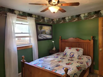 a bedroom with a bed with a ceiling fan at Lake Congamond Suffield House in Granby